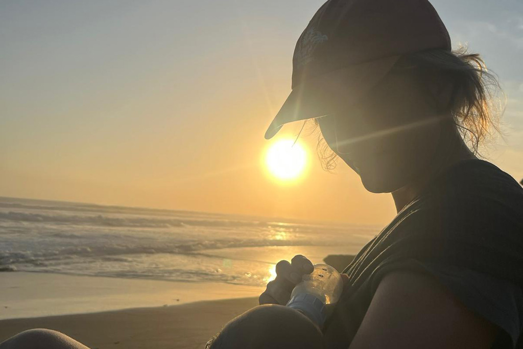 Baby auf Bali bekommen: Mutter gibt Baby ein die Flasche am Strand 