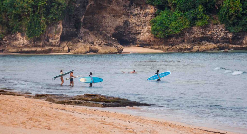 Surfer auf dem Weg ins Meer am Balangan Beach in Bali