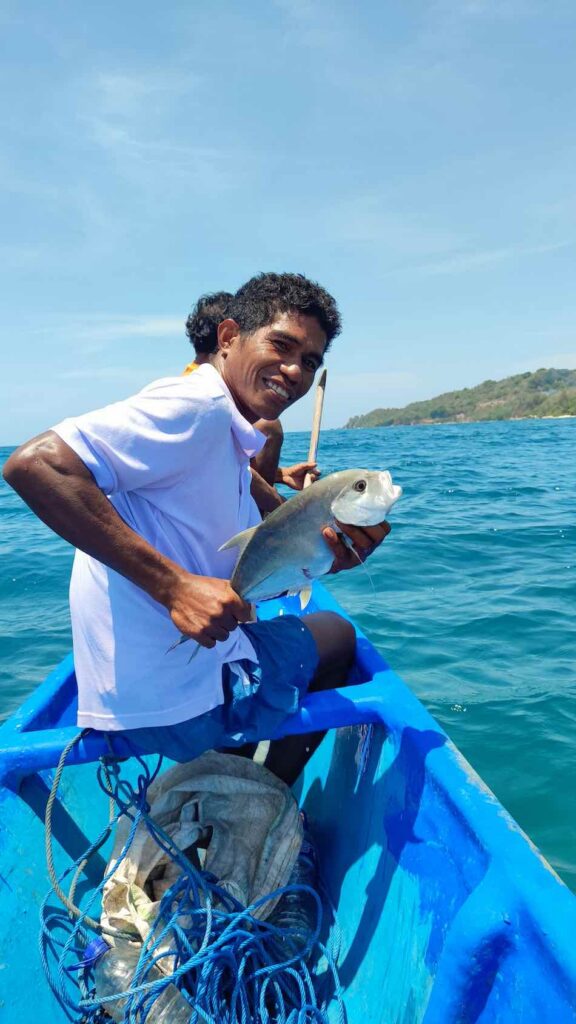 guide petrus zeigt stolz fisch beim angeln in sumba