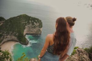paar blickt von aussichtspunkt auf kelingking beach nusa penida